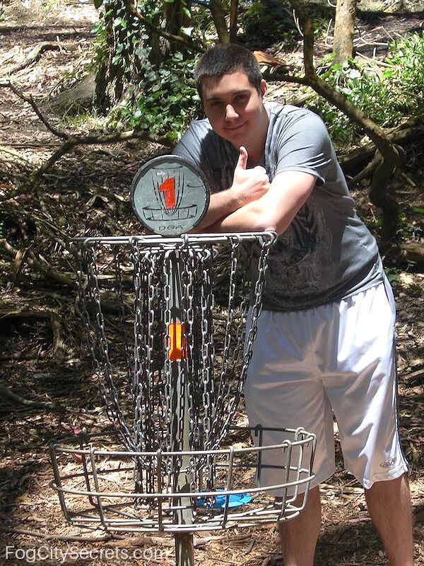 Disc golf player at basket Golden Gate Park SF