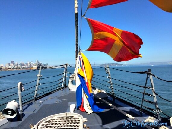 Flags flying on deck of SF Fleet Week navy ship during ship tour.