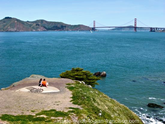 Couple admiring the view of the Golden Gate Bridge, at Lands End Point