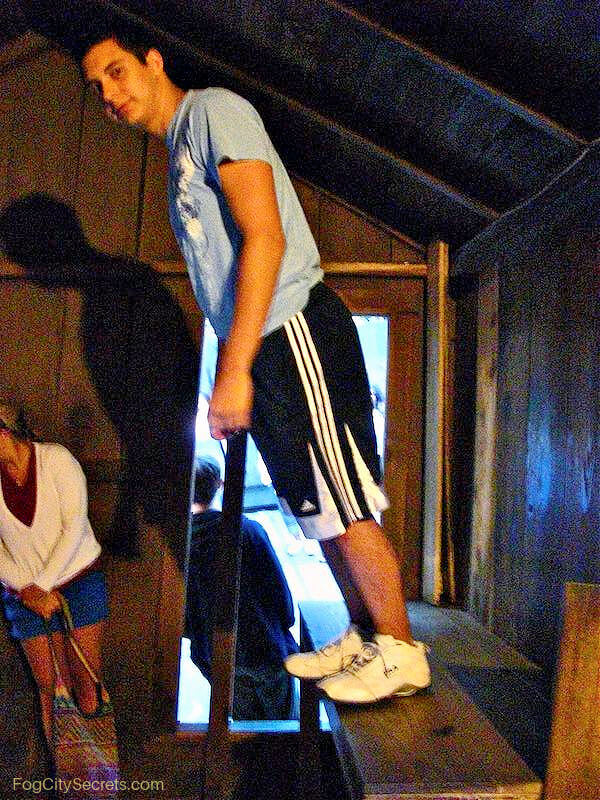 Man standing at an anglel in the Mystery Spot shack Man standing at an anglel in the Mystery Spot shack