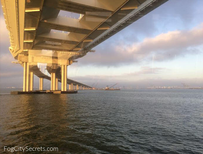 Oakland Bay Bridge sailing under in sunlight 