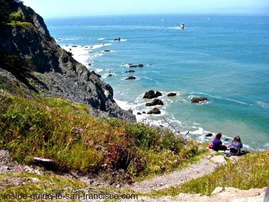 Two ladies sitting on cliff edge, Lands End trail